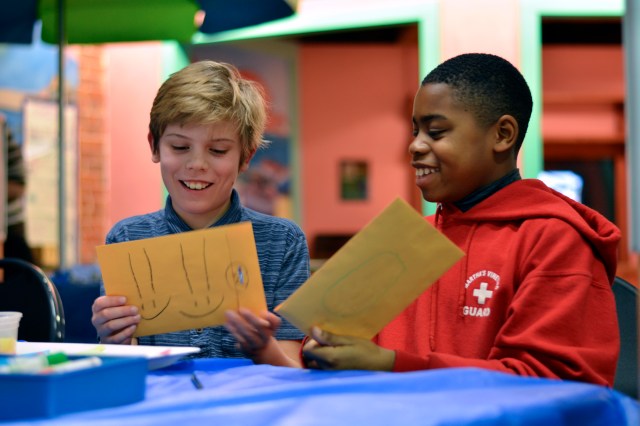 Two boys cut paper at the Boston Children's museum wekeend workshop