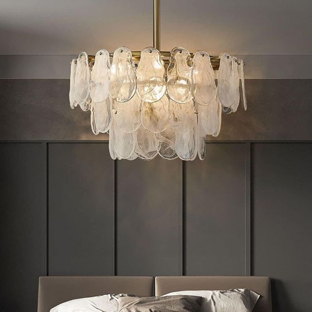 glass and brass chandelier hanging in grey bedroom