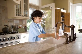 Boy washing hands at sink