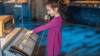A little girl explores interactive exhibits at the Oregon Historical Society during a free and discount museum day