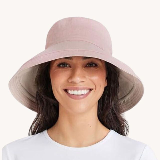 brunette woman wearing blush colored sun hat