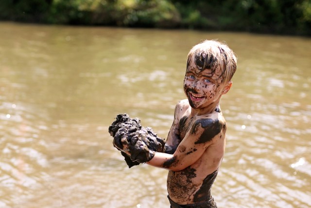 kid playing in mud as an outdoor adventure