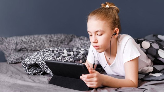 teen girl with headphones and ipad