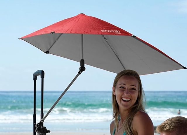 woman on beach under umbrella clamped to bag