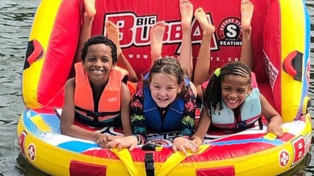 three kids are tubing at a local lakes near Atlanta on a sunny day