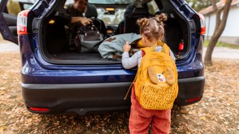 a picture of a little girl with a backpack that includes what you need to pack for daycare