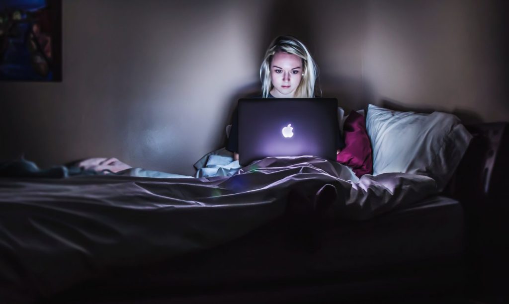 woman in bed on computer