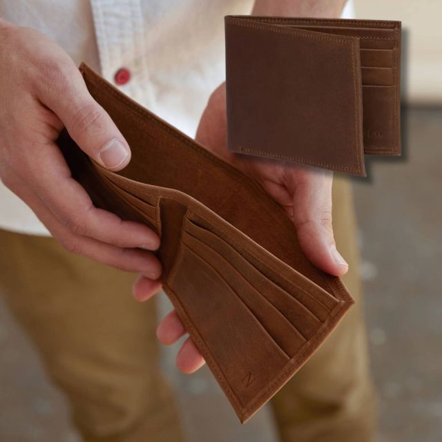 man holding brown leather bi-fold wallet