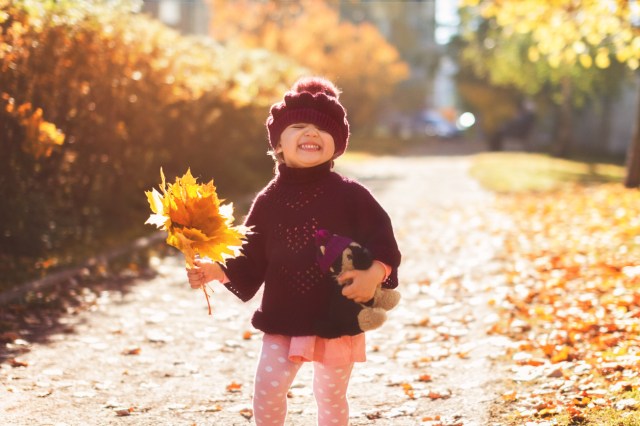 A happy little girl in fall celebrating her November birthday