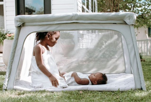 baby and older sister playing outside in a play yard