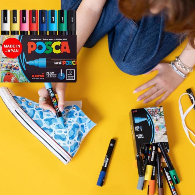 woman using paint pens to decorate sneaker