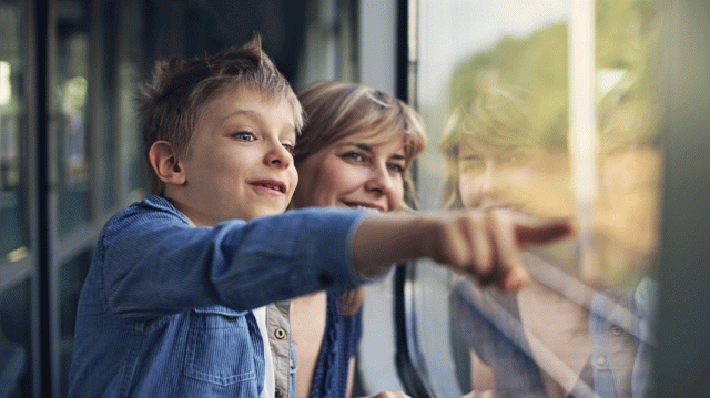 A mom and boy ride a train together
