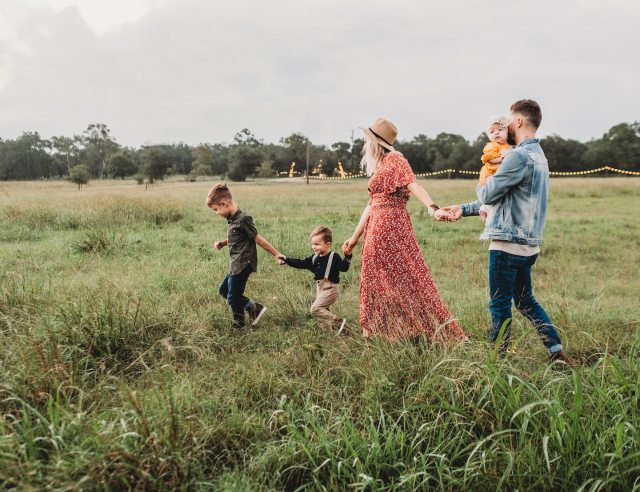 family walking in a field for Christmas card photo
