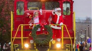 Santa and Mrs. Claus wave from a Polar Express train ride near Atlanta where kids can see Santa on a holiday train