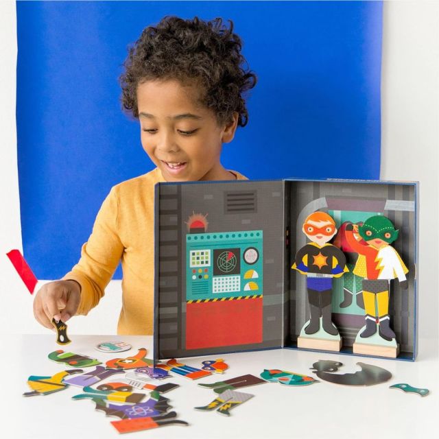 little boy playing with magnetic superhero dress up set