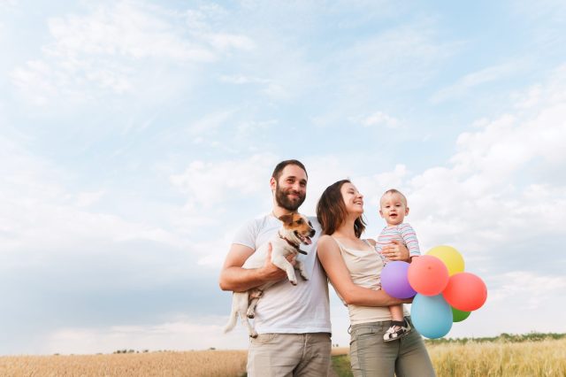 mom, dad, child and dog smiling with balloons first birthday party venue
