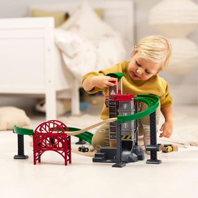 little boy playing with toy train set