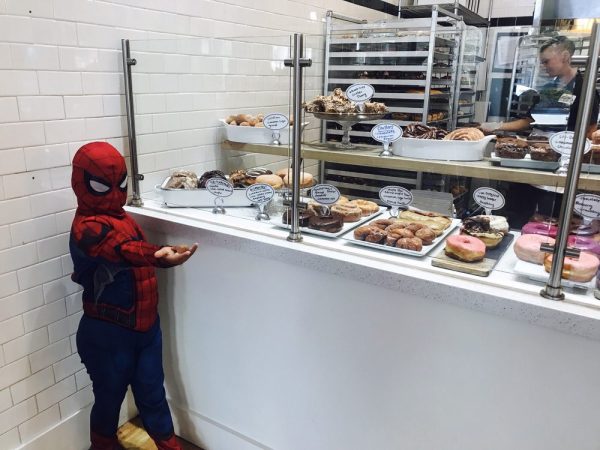 A boy stands at the counter for Johnny Donuts