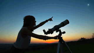 person pointing at the sky with telescope stargazing