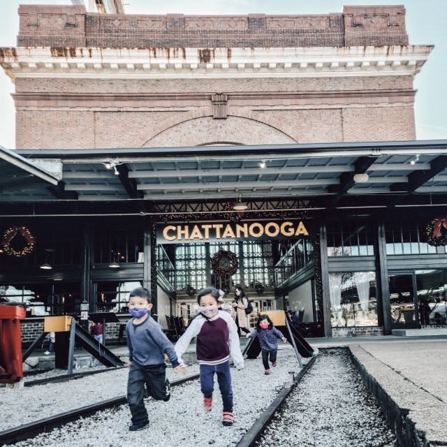 three children running away from Chattnooga sign