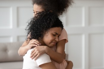A mother gives her daughter an encouraging hug