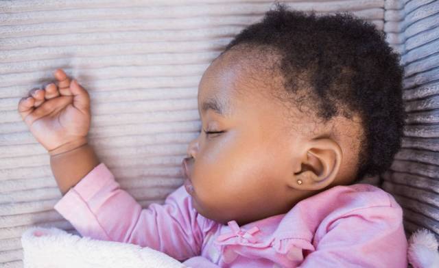 Black baby sleeping in crib - baby sleep guide