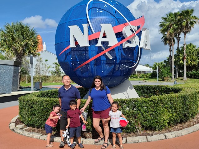 family of five standing in front of NASA sign