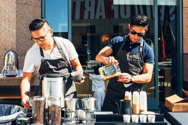 Two asian baristas prepare coffee