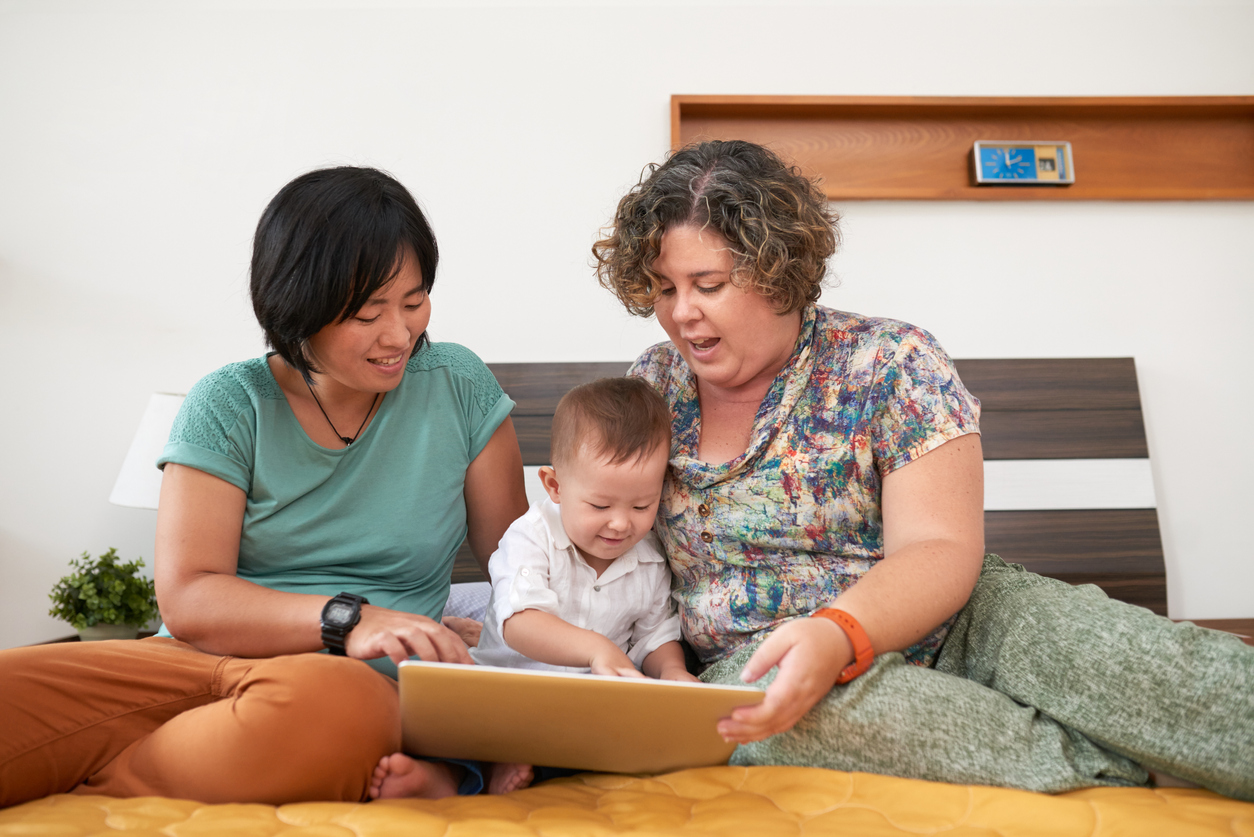 Mothers playing with child, same sex family, happy toddler