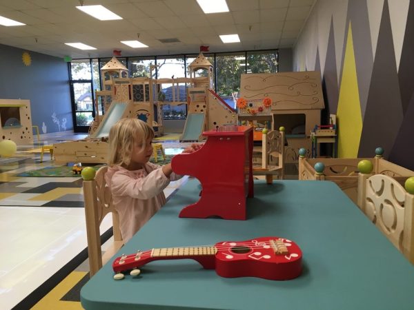 A girl plays with blocks at an indoor playspace