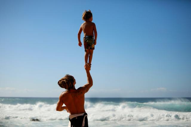 dad lifting kid beach
