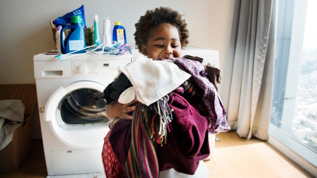 little boy doing laundry, a good thing to put on a chore list for kids ages 8-10