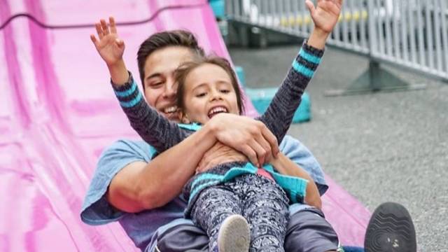 a girl and dad on a giant slide at fathers day activities in seattle