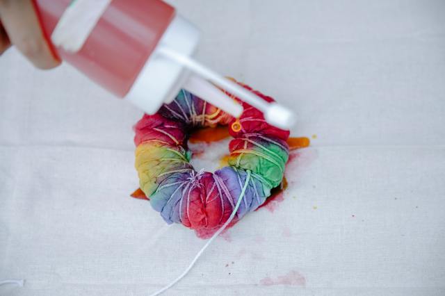 Fabric being dyed with rainbow colors for summer tie dying 