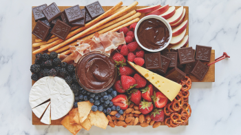 a charcuterie board for summer with chocolate and strawberries