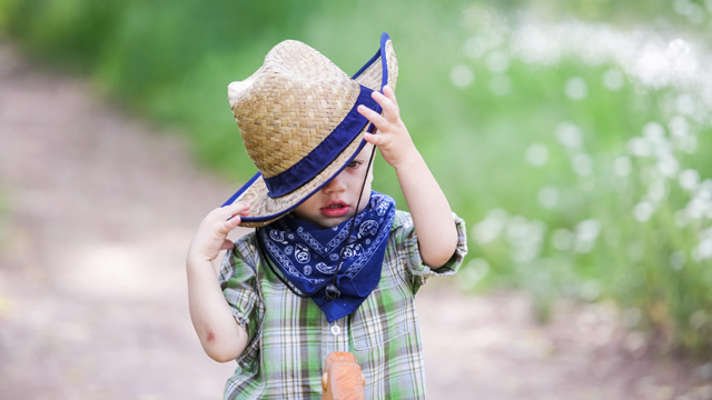 little boy in a cowboy hat playing farm games