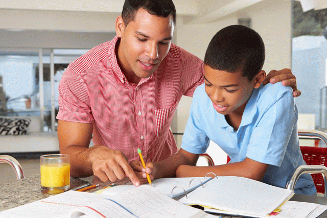 A father helps his son with homework