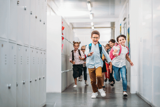 Happy kids run through the hall as they go back to school