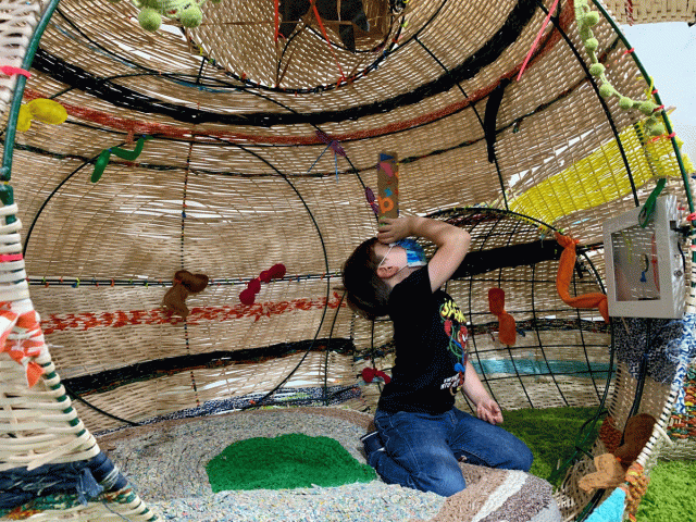 A boy plays inside an exhibit at Children's Museum of Manhattan