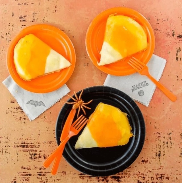 Three chicken quesadillas that look like candy corn sit on black and orange plates for a Halloween themed dinner