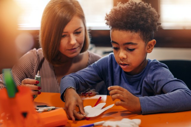 mother and son doing a craft at a table
