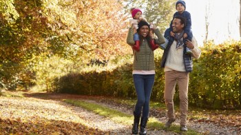 parents have kids on their shoulders during a fall hike