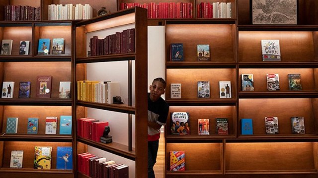 Boy opening hidden door in bookstore