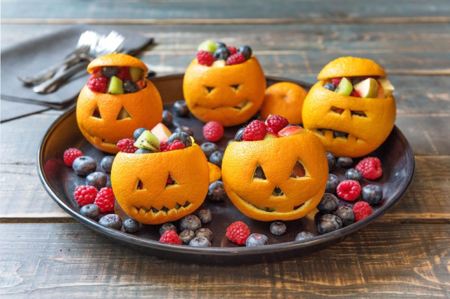 Five oranges that are "carved" to look like jack-o-lanterns is a fun Halloween dinner idea