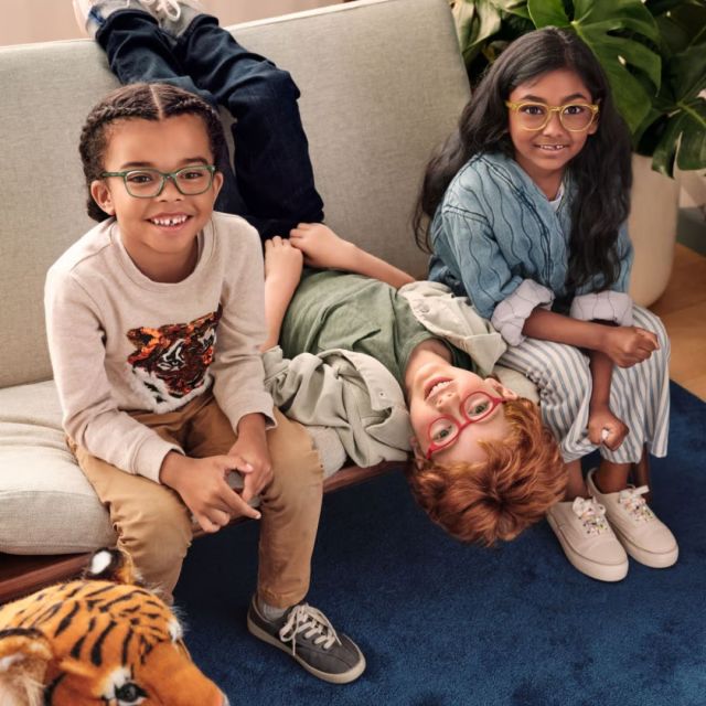 three kids on a couch wearing eye glasses