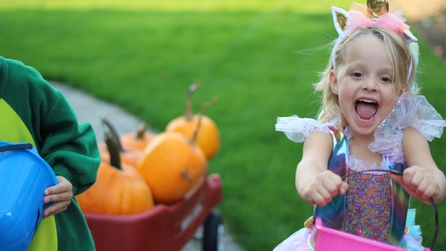 a girl in a unicorn costume with a trick or treat bucket gets ready to go out in Seattle