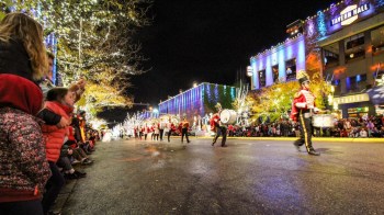 a band marches down the lit street outside Bellevue Snowflake Lane during the holidays