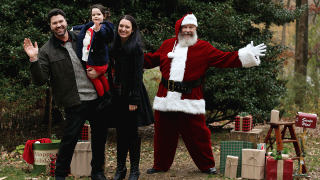 Santa poses outdoors with a family during a private Santa photo experience in New York City.