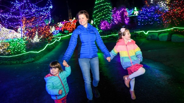 a mother and daughters walk along the path at Point Defiance zoo one of the seattle christmas lights displays families love
