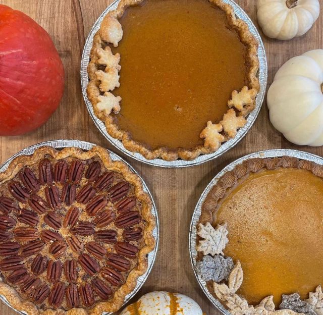 three kinds of pies surrounded by pumpkins for Thanksgiving dinner in seattle